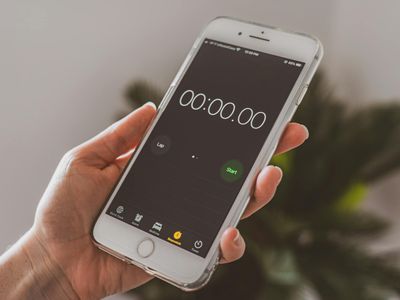 Hands holding a stopwatch during a morning workout session.