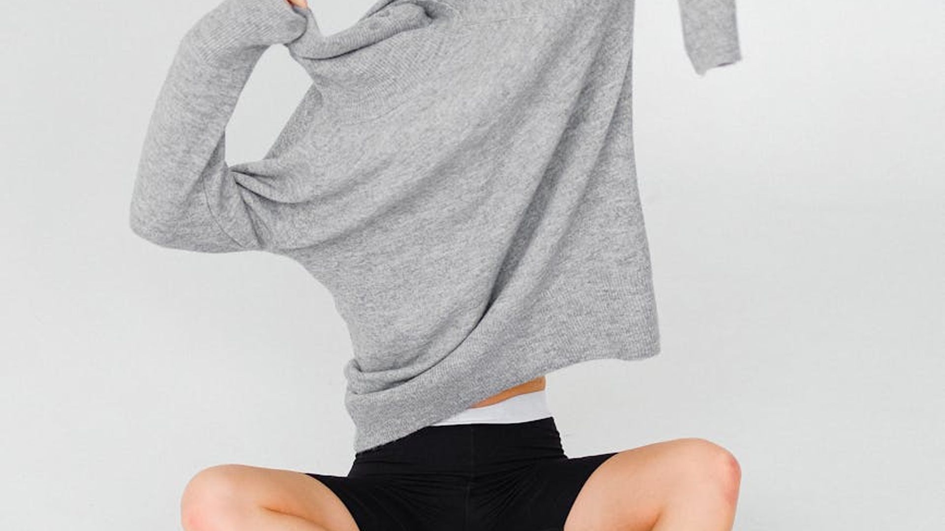 Person doing dynamic movements in a bright airy studio space.